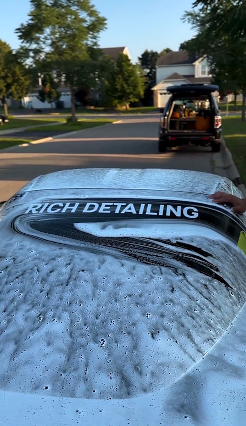 SUV covered in foam with Rich Detailing sunshade